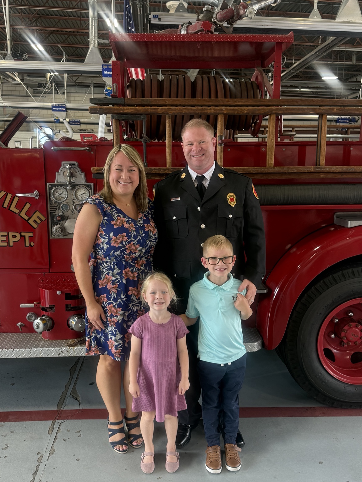Nate with his family in front of a vintage fire engine